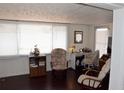 Inviting living room with lots of natural light from several windows; complete with comfortable seating and wood-look floors at 4922 Genesis Ave, Holiday, FL 34690