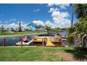 Spacious backyard featuring a screened-in patio, waterfront access, lush landscaping, and ample greenery at 5144 Cedarbrook Ln, Hernando Beach, FL 34607