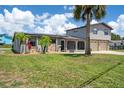 Charming two-story home with stone accents, solar panels, a two-car garage, and lush green landscaping at 5144 Cedarbrook Ln, Hernando Beach, FL 34607