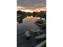 Scenic waterfront view with dock, boats, and a mosaic table set against a vibrant sunset at 5144 Cedarbrook Ln, Hernando Beach, FL 34607