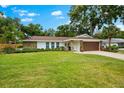 Charming one-story home featuring stone accents, a manicured lawn, and a two-car garage at 535 Sandy Hook, Palm Harbor, FL 34683