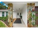 Covered entry featuring stone columns and stylish double doors, creating a welcoming entrance to the home at 535 Sandy Hook, Palm Harbor, FL 34683