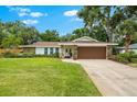Charming single-story home featuring a manicured lawn, stone accents, and a two-car garage at 535 Sandy Hook, Palm Harbor, FL 34683