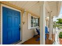 Inviting front porch with a bright blue door and comfortable seating area at 6111 2Nd Ave, New Port Richey, FL 34653