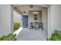 Charming front porch with elegant chairs, a blue front door, and decorative plants at 7225 Ronnie Gardens Ct, Tampa, FL 33619