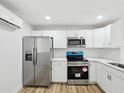 Bright kitchen with stainless steel appliances, white cabinets, and subway tile backsplash at 7813 Cadillac Ave, Hudson, FL 34667