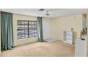 Bright living room with neutral carpet, ample natural light, and a ceiling fan at 8246 Westfield Dr, Port Richey, FL 34668