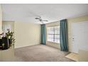 Open-concept living room featuring neutral carpet, ceiling fan, and easy access at 8246 Westfield Dr, Port Richey, FL 34668