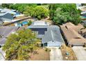 Aerial view of a property with a solar-paneled roof and an enclosed private pool at 8737 Beaver Ln, Port Richey, FL 34668