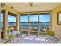 Enclosed lanai with tile flooring, waterfront views, and comfortable seating area at 8931 Blind Pass Rd # 262, St Pete Beach, FL 33706