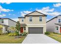 Charming home with a two-car garage, landscaped front yard, and a vibrant red front door at 9313 Lemon Drop Loop, Sun City Center, FL 33573