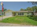 Inviting single-story home with lush front lawn and attached garage on a sunny day at 9930 121 N St, Seminole, FL 33772