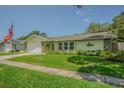 Lovely single-story home with well-kept lawn, stone detail, and an attached garage at 9930 121 N St, Seminole, FL 33772