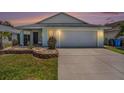 Inviting single-story home with a well-manicured lawn, a small patio, and an attached garage at 1106 Humble Haven St, Ruskin, FL 33570