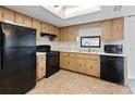 Functional kitchen featuring black appliances, wood cabinets, and white countertops at 11305 Brown Bear Ln, Port Richey, FL 34668