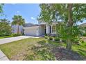Charming residence offering well-maintained landscaping, a spacious driveway, and an attached two-car garage at 11408 Coventry Grove Cir, Lithia, FL 33547