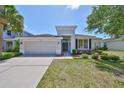Inviting home showcasing lush landscaping, a two-car garage, and a welcoming front entrance at 11408 Coventry Grove Cir, Lithia, FL 33547
