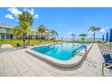 Outdoor pool surrounded by palm trees and lounge chairs overlooking a bay at 1351 Gulf Blvd # 209, Clearwater Beach, FL 33767