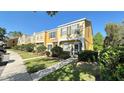Well-maintained two-story townhome with lush green lawn and mature landscaping at 1400 Costa Mesa Dr, Wesley Chapel, FL 33543