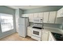 Functional kitchen featuring white appliances, ample storage, and a window for natural light at 1400 Costa Mesa Dr, Wesley Chapel, FL 33543
