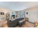 Inviting living room featuring wood floors, neutral wall colors, large windows, and comfortable seating at 1433 Spring Ln, Clearwater, FL 33755