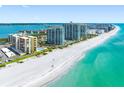 Aerial view showcasing beachfront condos with pristine white sands and turquoise waters at 1480 Gulf Blvd # 1004, Clearwater Beach, FL 33767
