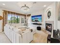 Bright living room features a fireplace, large sectional, and an oversized tv with a view at 1532 Citrine Trl, Tarpon Springs, FL 34689