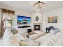 Inviting living room with a fireplace, piano, comfy sectional sofa, and bright chandelier at 1532 Citrine Trl, Tarpon Springs, FL 34689