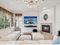 Bright living room featuring a fireplace, large TV, comfortable white seating, and elegant chandelier at 1532 Citrine Trl, Tarpon Springs, FL 34689