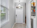 Bright foyer featuring tile flooring, modern light fixture, and a convenient laundry area at 1811 Redmond Brook Ln, Ruskin, FL 33570