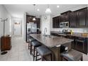 Open kitchen featuring dark wood cabinets, stainless steel appliances, and a spacious center island with bar seating at 1811 Redmond Brook Ln, Ruskin, FL 33570