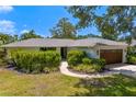 Inviting single-story home with manicured front lawn and lush landscaping at 2665 Clubhouse N Dr, Clearwater, FL 33761