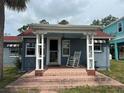 Inviting front porch with brick steps, white columns, and a classic rocking chair at 3007 Clinton S St, Gulfport, FL 33707