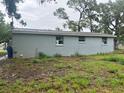 Rear view of the home, showing the exterior, roofline, and windows against a green yard at 310 2Nd Nw Ave, Ruskin, FL 33570