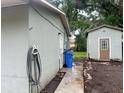 View of the side yard featuring an exterior building, utility box, and partial view of an adjacent yard at 310 2Nd Nw Ave, Ruskin, FL 33570