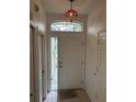 A front door with a window above, tiled entry and a decorative light fixture at 3145 Meta Ct, Largo, FL 33771