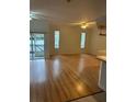 Spacious living room with hardwood flooring, ceiling fans, and a sliding door to the outside at 3145 Meta Ct, Largo, FL 33771