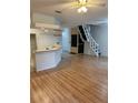 Living room featuring hardwood floors, a kitchen view, and stairs to the second floor at 3145 Meta Ct, Largo, FL 33771