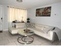 Cozy living room with modern white sofa, glass-top coffee table, and elegant decor at 3424 Truman Dr, Holiday, FL 34691
