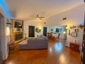 Open-concept living room with a brick fireplace, ceiling fan, and hardwood floors, perfect for entertaining at 35058 Whispering Oaks Blvd, Dade City, FL 33523