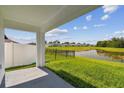 Covered back patio overlooking the lush green yard and tranquil pond, perfect for relaxing outdoors at 36673 Spanish Rose Dr, Dade City, FL 33525