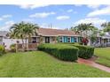 Attractive home with a well-maintained lawn, mature palm trees, and a cozy wooden porch at 3800 6Th N Ave, St Petersburg, FL 33713