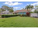 Well-maintained home featuring a lush green lawn, manicured hedge, and vibrant blue shutters enhancing curb appeal at 3800 6Th N Ave, St Petersburg, FL 33713