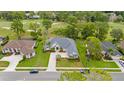 Expansive aerial view showcases the home's layout with a well-kept lawn, mature trees, and surrounding neighborhood at 5182 Championship Cup Ln, Spring Hill, FL 34609