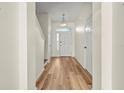 Inviting entryway with wood flooring, a modern chandelier, and a white front door at 568 Shoreham Ne Ct, St Petersburg, FL 33716