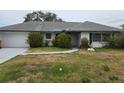 Single-story home featuring a gray roof, white exterior, and a two-car garage at 5688 Oakhurst Dr, Seminole, FL 33772
