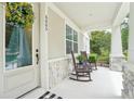 Inviting front porch with stone accents, seating, and view of well-manicured landscaping at 6005 Shell Ridge Dr, Lithia, FL 33547