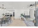 Open-concept living space with sleek ceiling fan, neutral decor, and hardwood flooring transitioning into a kitchen area at 7 Hamilton Heath Dr, Tampa, FL 33604