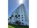 Exterior shot of the building showing landscaping, palm trees and glass windows from a low angle on a sunny day at 7200 Sunshine Skyway S Ln # 2E, St Petersburg, FL 33711