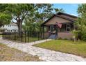 Charming bungalow with a quaint front porch, flag, walkway lighting, and manicured landscaping at 931 28Th N Ave, St Petersburg, FL 33704